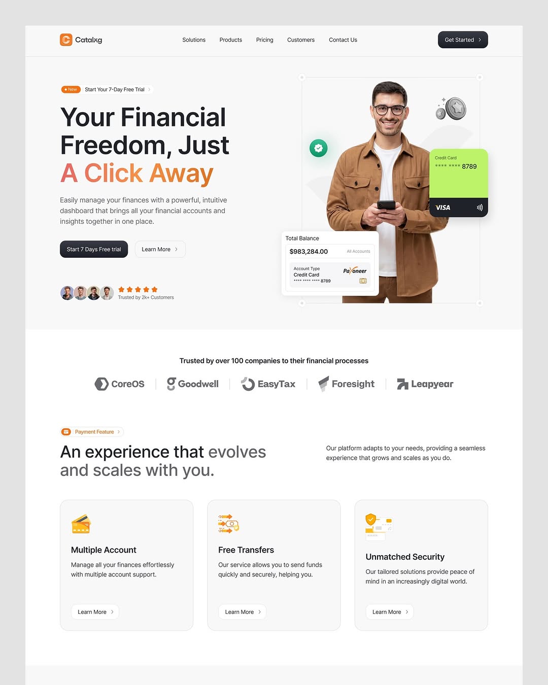 Hero section of the Catalog finance platform showing a man holding a phone next to a digital credit card and account balance widget. Headline reads 'Your Financial Freedom, Just A Click Away.' Includes logos of trusted partner companies.